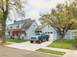 a blue truck parked in driveways in front of a house