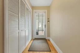 a hallway with a door and white cabinets
