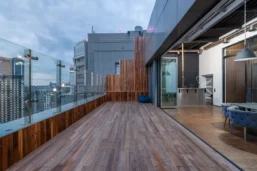 a balcony with a wood deck and glass walls