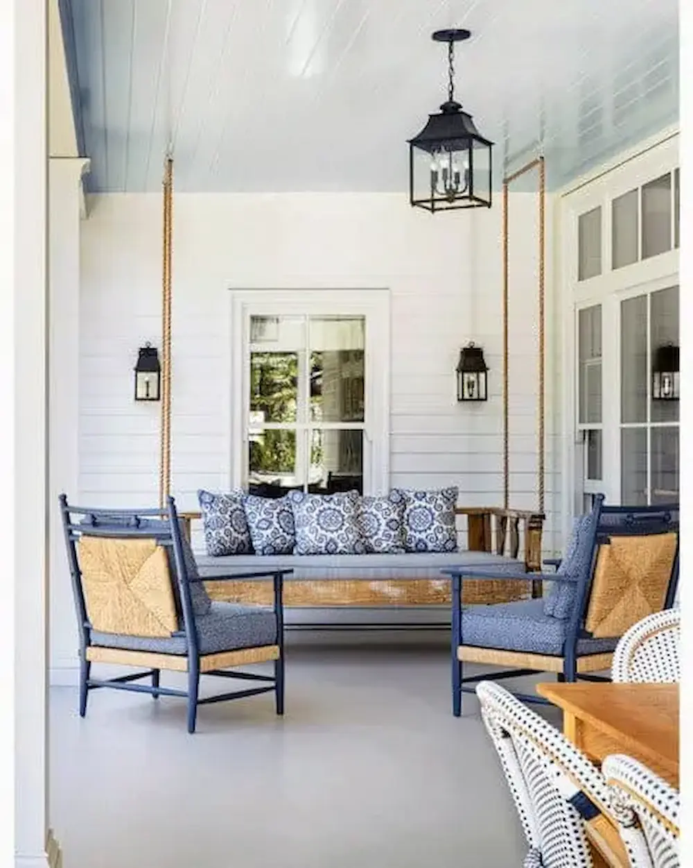 a porch with a swing and chairs