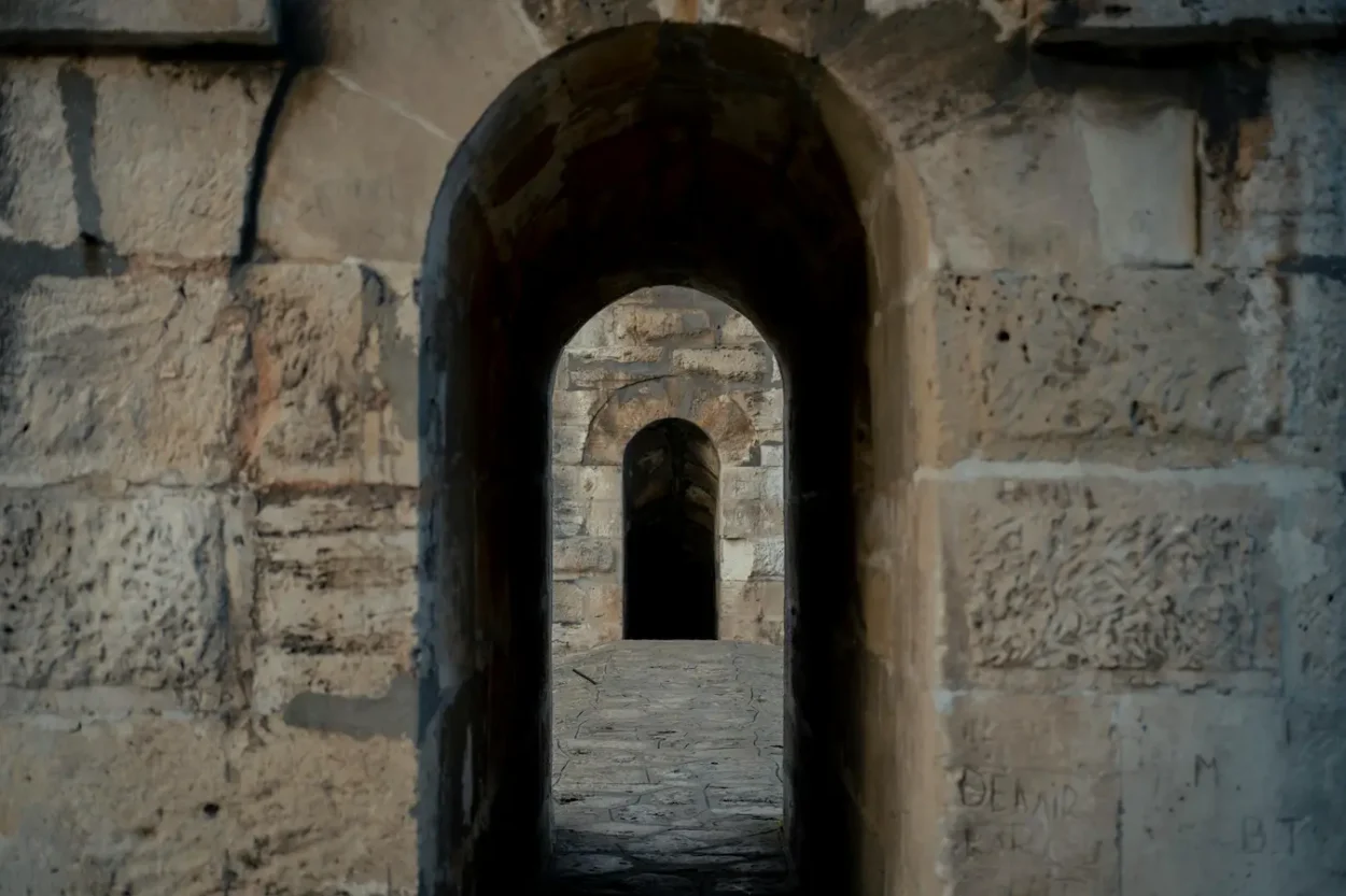 a stone archway with a stone walkway